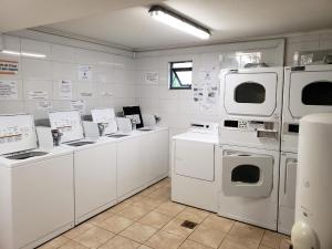 lavadero con electrodomésticos blancos y armarios blancos en Cuatro Norte 955 Apartamento Full equipado, en Talca