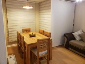 a dining room with a table and chairs and a couch at Cuatro Norte 955 Apartamento Full equipado in Talca