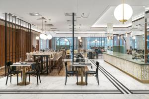 a restaurant with tables and chairs and a bar at Metropolo by Golden Tulip Krakow in Krakow