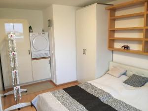 a bedroom with a bed and a washing machine at ZENTRUMNAH direkt an UBAHN bei UN-VIC und am BADESTRAND in Vienna
