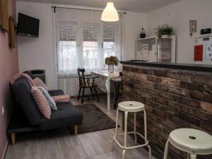 a living room with a brick wall and a bar at Apartment Dubovac in Karlovac