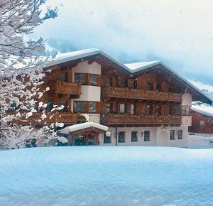 ein großes Gebäude mit Schnee vor der Tür in der Unterkunft Stacklerhof in Neustift im Stubaital