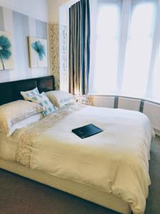Una cama con un libro negro encima. en Rutland West Guest House, en Filey