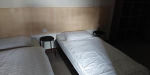 twee bedden in een kleine kamer met twee stoelen bij T Hotel in Tawau