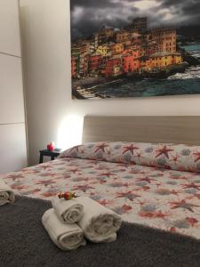 - une chambre avec un lit et des serviettes dans l'établissement Colombo House, à Gênes