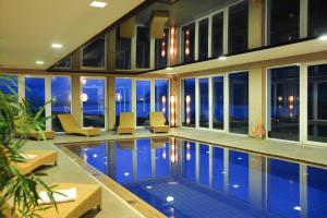 basen w domu z krzesłami i oknami w obiekcie Vital Hotel Ortlerspitz w mieście San Valentino alla Muta