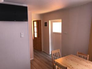 a dining room with a table and a television on a wall at Domek Parterowy in Gąski