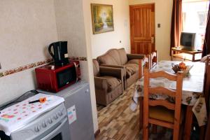 uma cozinha e sala de estar com fogão e micro-ondas em Cabanas Via Nautica em Algarrobo