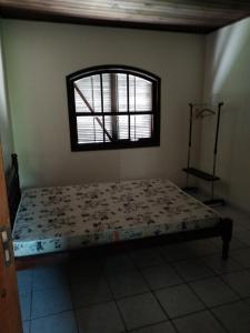 a bedroom with a bed in a room with a window at Casa na praia in Itapoa