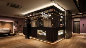 a man standing in a room with a display case at Bespoke Hotel Shinjuku in Tokyo