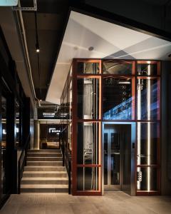 東京的住宿－Bespoke Hotel Shinjuku，通往带玻璃门的建筑的楼梯