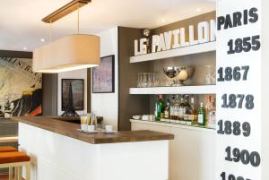 eine Bar in einem Restaurant mit einem Schild an der Wand in der Unterkunft Hôtel de l'Exposition - Tour Eiffel in Paris