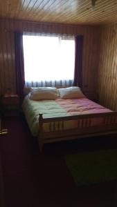 a bed in a room with a window at Cabaña Dalcahue Avenida Mocopulli in Dalcahue +70 photos