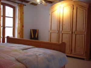 ノイシェーナウにあるFerienwohnung Späthのベッドルーム1室(ベッド1台付)、大きな木製キャビネットが備わります。