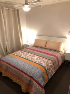 1 dormitorio con 1 cama con 2 lámparas y 2 mesas en Glenelg Street, en Perth