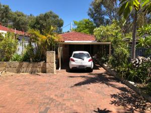 un coche blanco estacionado frente a un garaje en 5A Glenelg Street en Perth