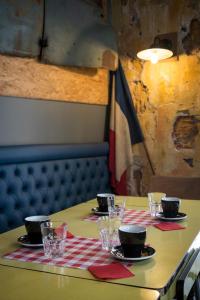 a table with plates and glasses on top at Hôtel Le G (ex Le Genève) in Nice