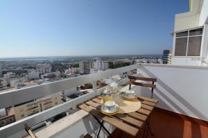 einen Tisch auf einem Balkon mit Stadtblick in der Unterkunft Wonderful view in the city center in Faro