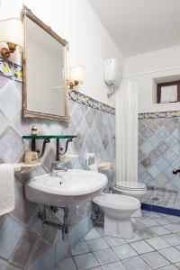 bagno con lavandino, servizi igienici e specchio di The Sea Farmhouse a Sorrento