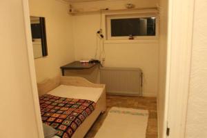 um pequeno quarto com uma cama e uma janela em Kassie & Gia's Home em Vestnanhavn