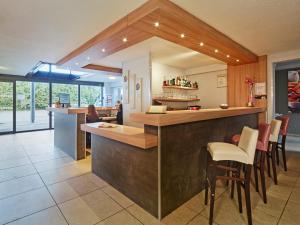 a kitchen with a counter and chairs in a room at Kyriad Auxerre Appoigny in Appoigny