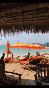 grupa parasoli i leżaków na plaży w obiekcie Nautilus Right on the Beach - Adult Only - SHA Extra Plus w mieście Ko Lanta