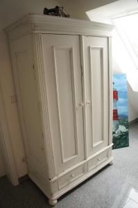 a white cabinet with two doors in a room at Dachstudio Bisping33 in Ascheberg