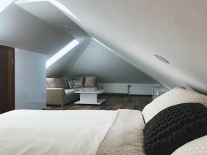 a attic bedroom with a bed and a couch at Luxury Villa Kadic in Bjelašnica