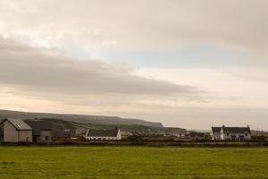un gruppo di case in un campo con colline sullo sfondo di Nellie Dee's - Room Only a Doolin Altre 16 foto