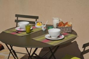 - une table avec des tasses et un panier de pain dans l'établissement L'Olivette, à Montagnac