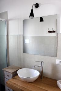 bagno con lavandino bianco e specchio di Residenze Branca II SeaView a Orosei