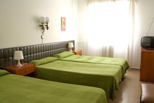 a bedroom with two beds and two lamps at Siracusa in Andorra la Vella