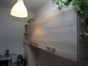 a kitchen with a wooden wall with a window at Apartment Dubovac in Karlovac
