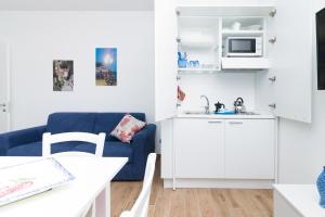 un soggiorno con divano blu e una cucina di Coast & Coast | Apartments a Piano di Sorrento