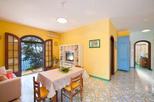 a dining room with a table and a living room at Casa Marea in Conca dei Marini +24 photos