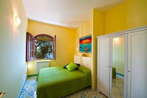ein Schlafzimmer mit einem grünen Bett und einem Fenster in der Unterkunft Casa Marea in Conca dei Marini