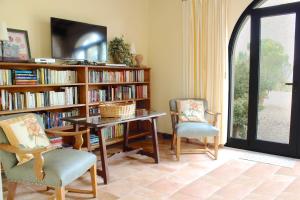 Fienile villa cottage في Bucine: غرفة مع طاولة وكرسيين ورف كتاب
