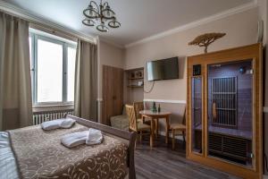 プラハにあるChampagne Studio with Saunaのベッドとダイニングルームが備わるホテルルームです。