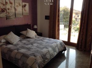 1 dormitorio con 1 cama y puerta corredera de cristal en G&G Bed&Breakfast and apartments, en Garda