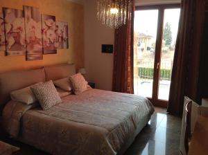 a bedroom with a large bed and a large window at G&G Bed&Breakfast and apartments in Garda