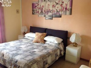 a bedroom with a bed, a desk, and a painting on the wall at G&G Bed&Breakfast and apartments in Garda