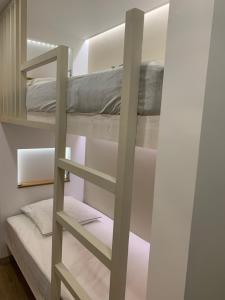 a bunk bed in a room with a ladder at Studio des Cintes Blanques in Aragnouet