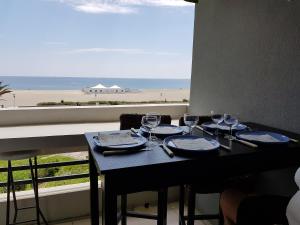 カネ・アン・ルシヨンにあるResidence Beaupreのビーチの景色を望むテーブル(ワイングラス付)