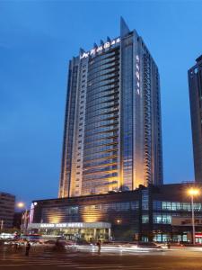 a tall building with lights in front of it at Grand View Hotel Tianjin in Tianjin