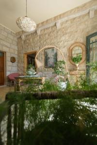 a living room with a stone wall and a table at Mresty Guest House in Al Mţullah