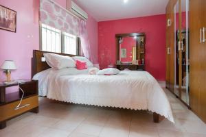 a bedroom with a large bed with pink walls at Mresty Guest House in Al Mţullah