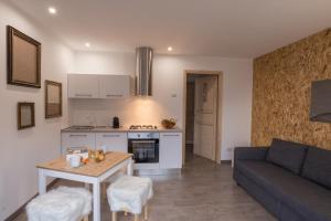 a kitchen and living room with a table and a couch at Ca' Dottori in Albosaggia