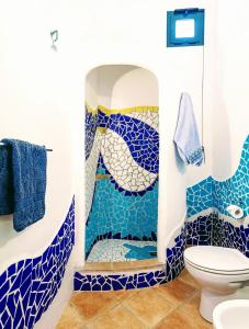 uma casa de banho com uma cabina de duche em mosaico azul e branco em Orosei RE - Il Paradiso degli Ulivi con vista mare em Orosei