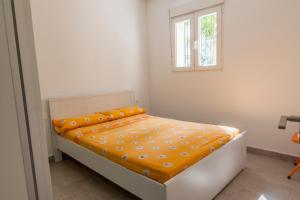 1 dormitorio con 1 cama con edredón de naranja y ventana en Apartamento cerca de la Playa y el Centro, en Valencia