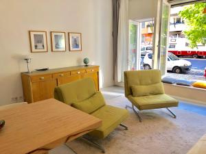 a living room with two chairs and a table and a window at Ladenwohnung in Kreuzberg mit Parkplatz in einer Tiefgarage in Berlin